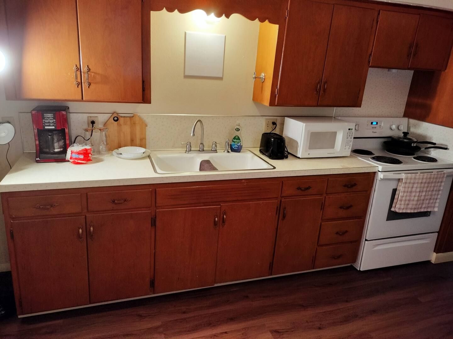A kitchen with a sink stove and microwave