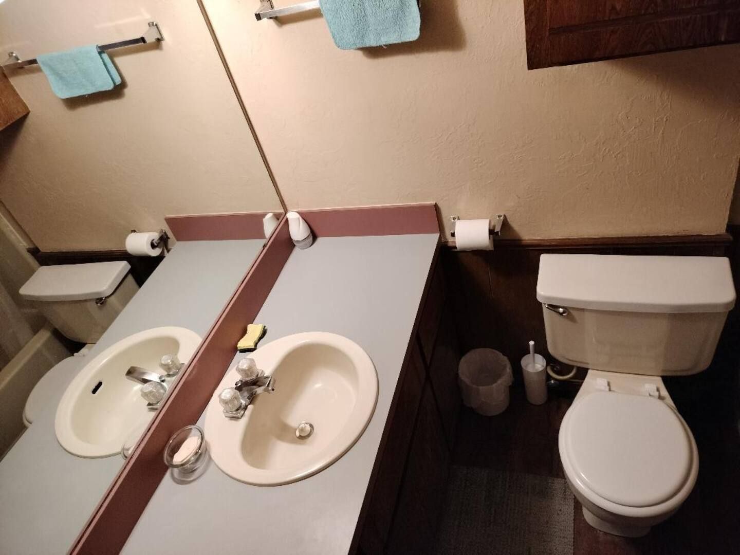 A bathroom with two sinks and a toilet