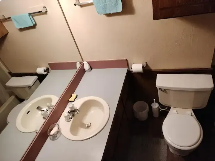 A bathroom with two sinks and a toilet