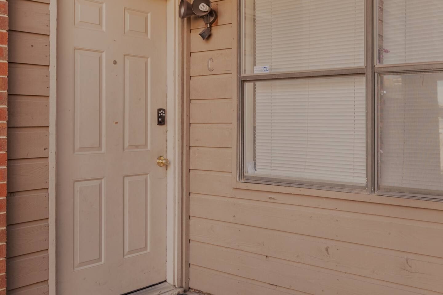 The front door of a house with a window and blinds.