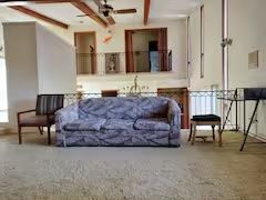 A living room with a couch and chairs in it.