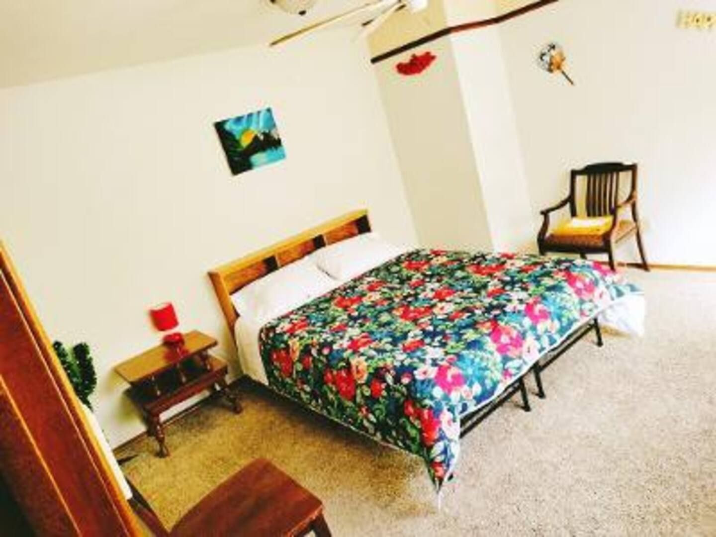 A bedroom with a large bed and a chair