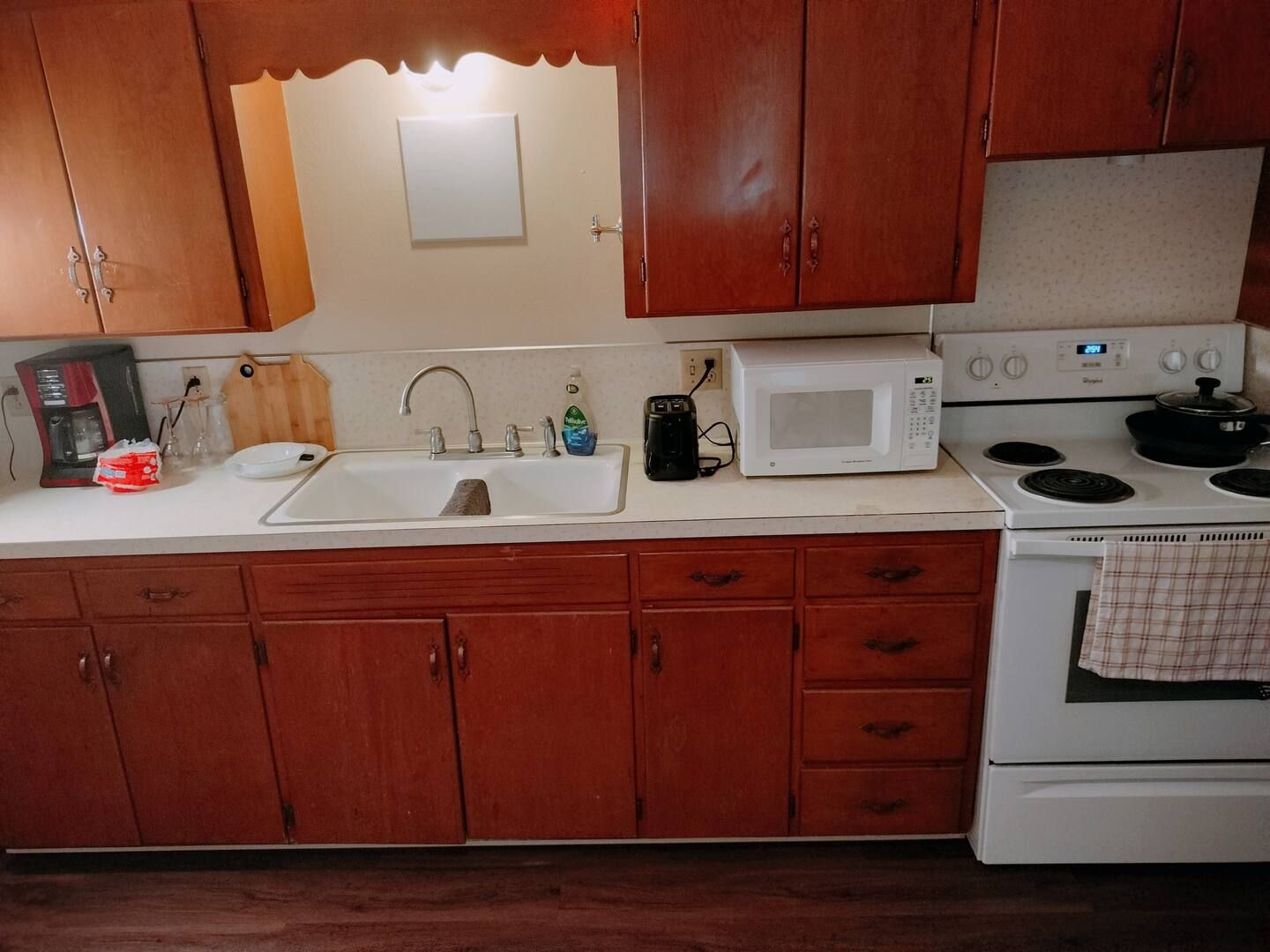 A kitchen with a sink stove and microwave