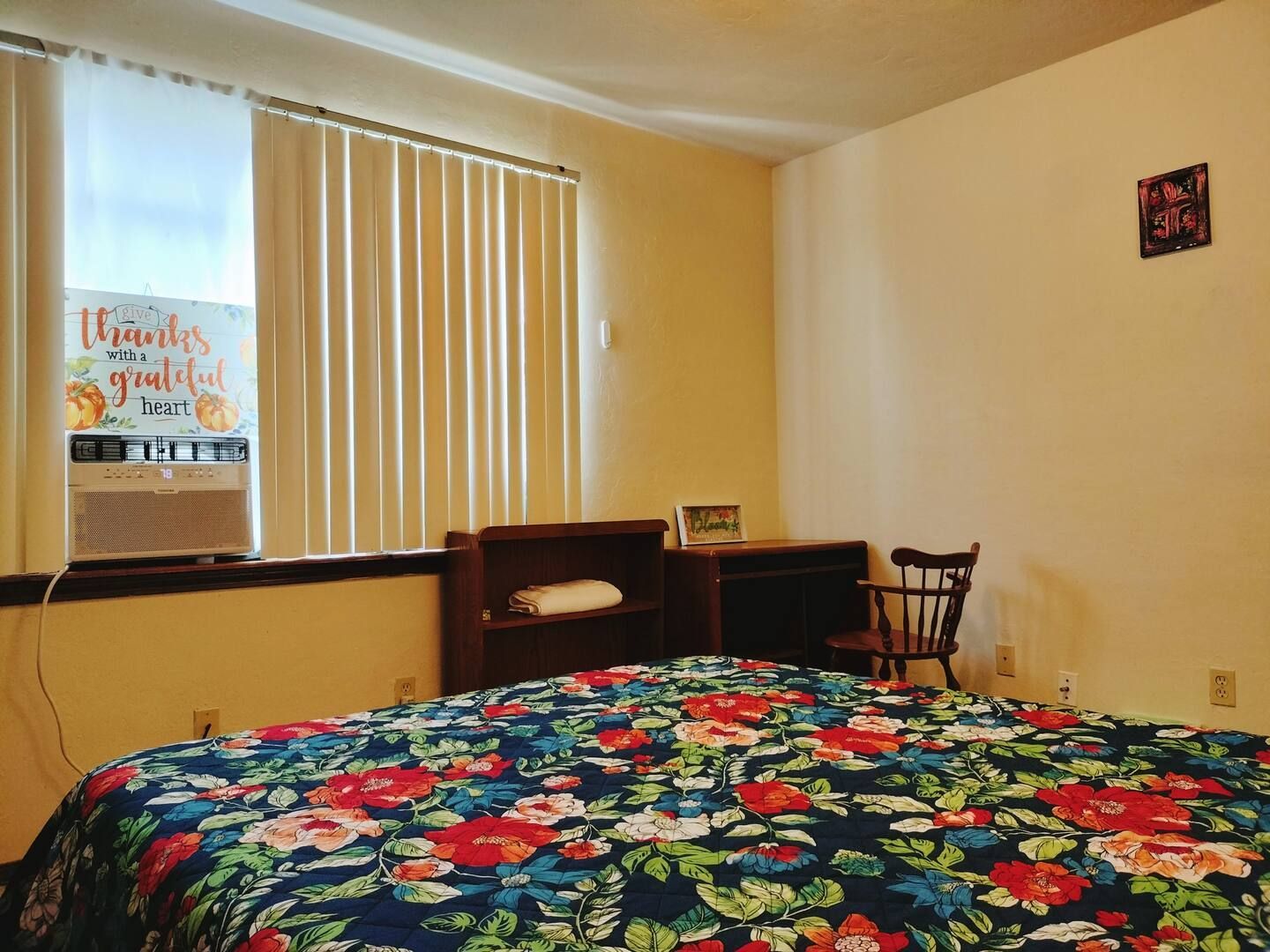 A bedroom with a bed and a sign that says thanks grateful