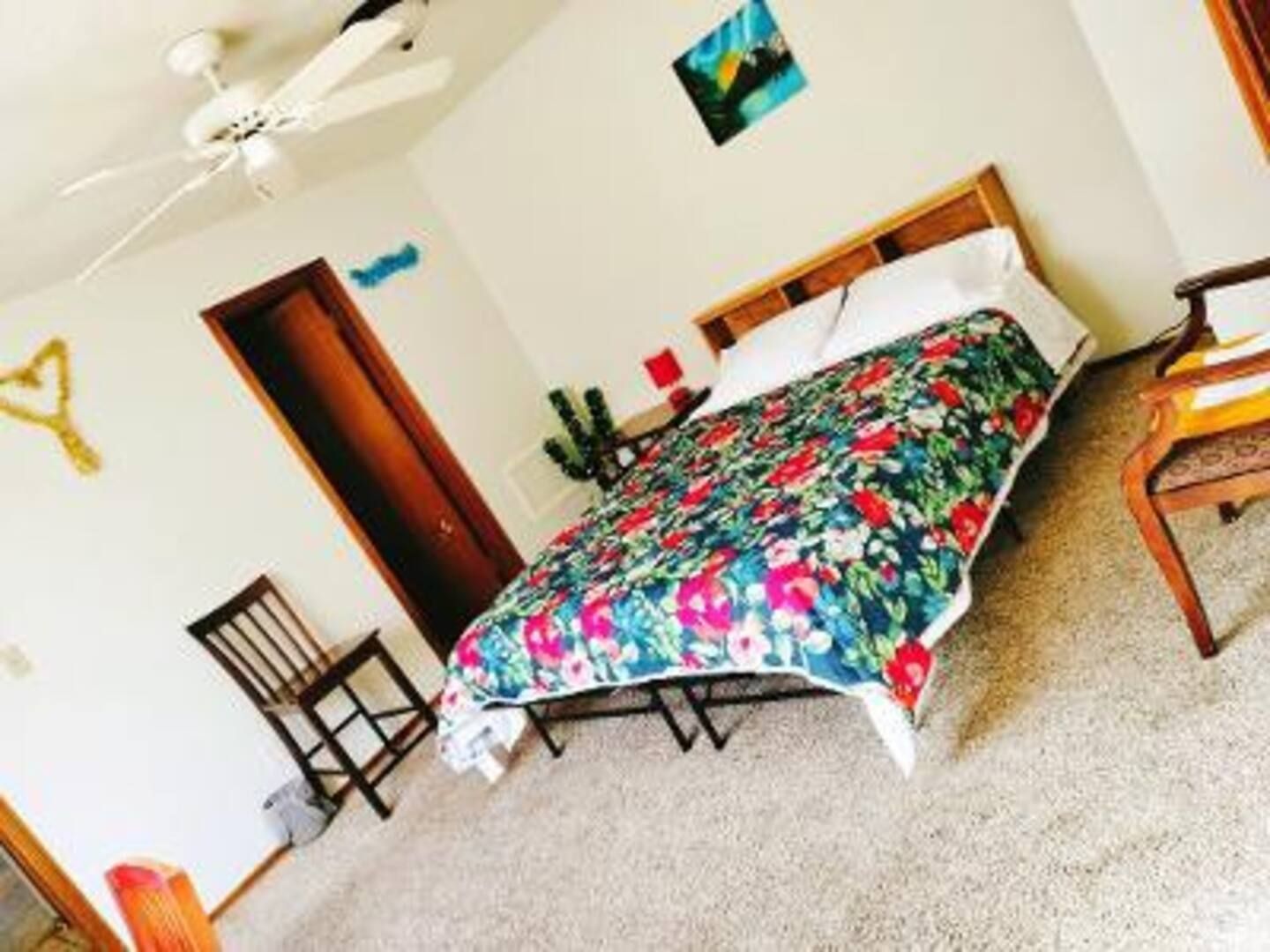 A bedroom with a large bed and a ceiling fan
