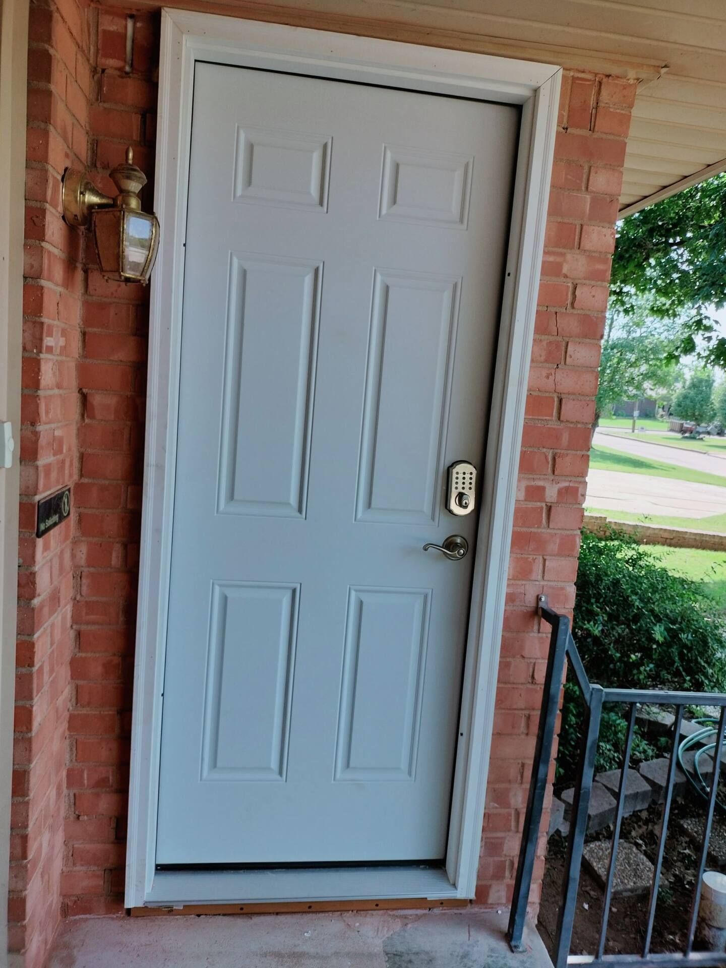 A white door is sitting on top of a brick wall.