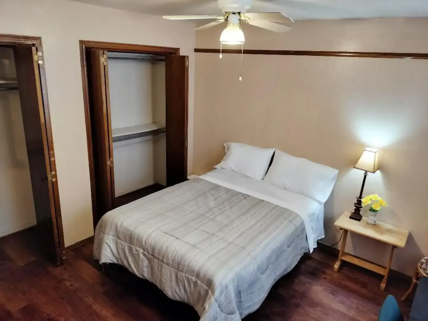 A bedroom with a bed and a ceiling fan