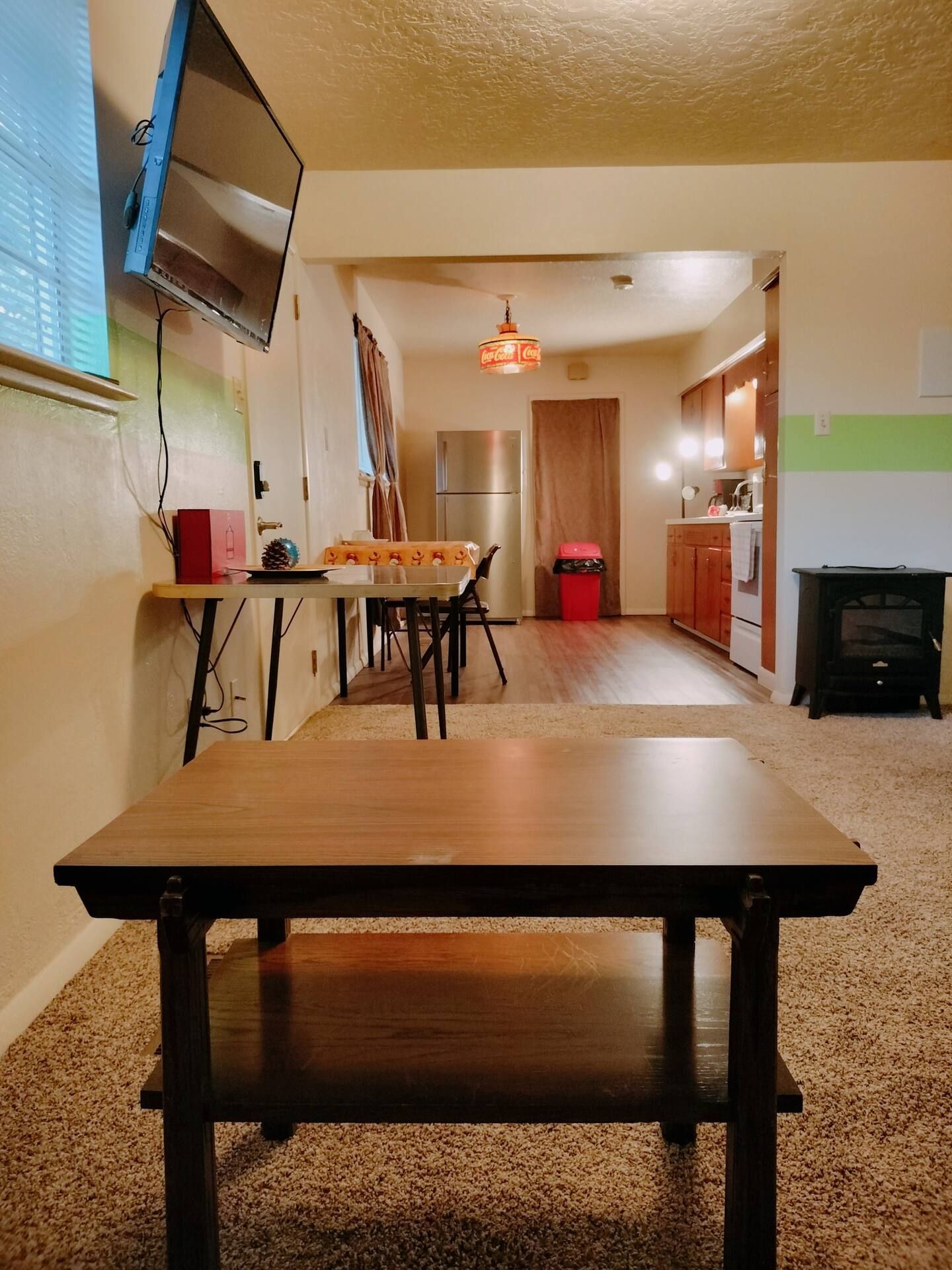 A living room with a coffee table and a flat screen tv