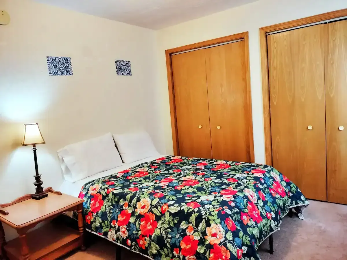 A bedroom with a floral blanket on the bed