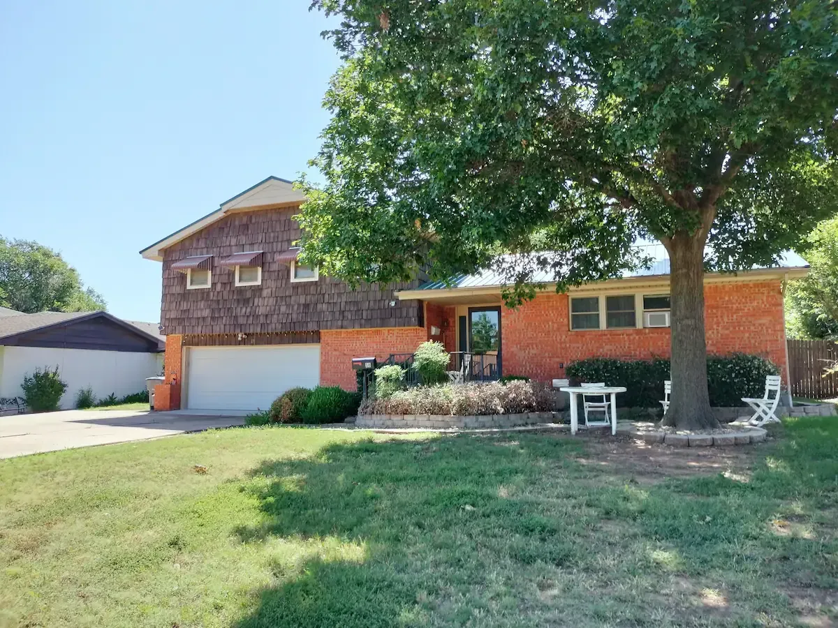 A brick house with a tree in front of it