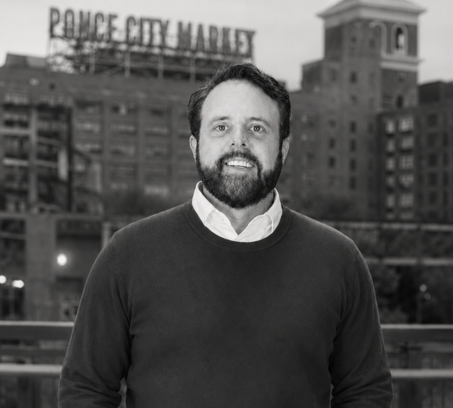 A man with a beard is wearing a black sweater