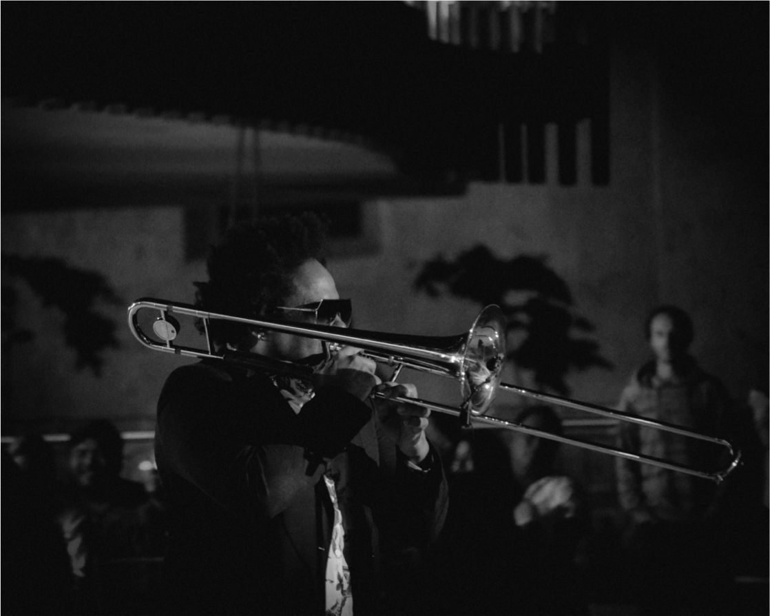 A man is playing a trombone in a black and white photo