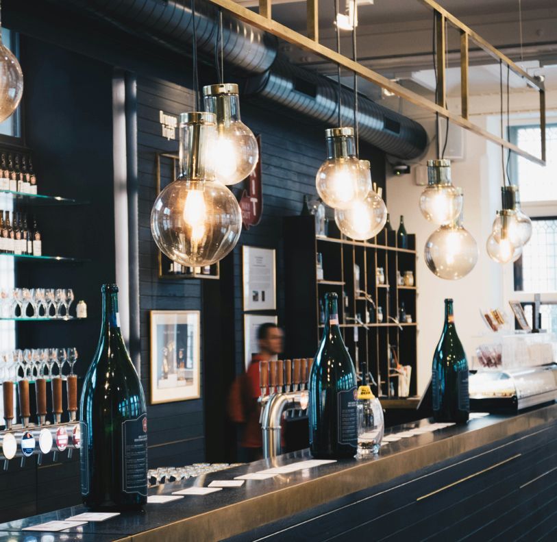 Bottles of alcohol are lined up on a bar in a restaurant