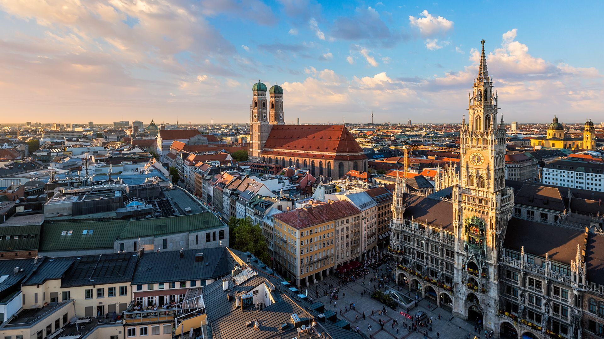 An aerial view of a city with a large clock tower in the middle of it.