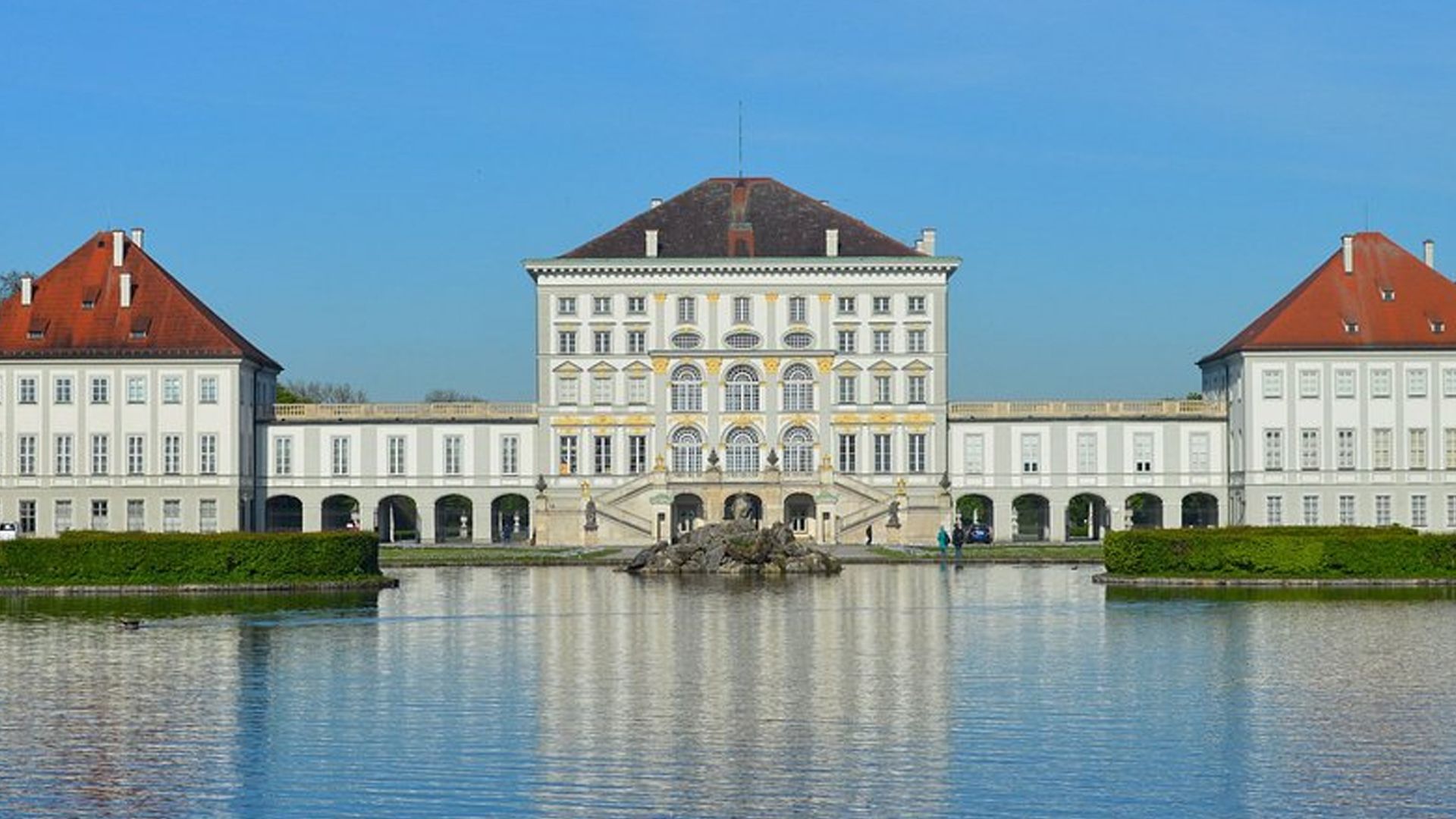 A large building with a lake in front of it