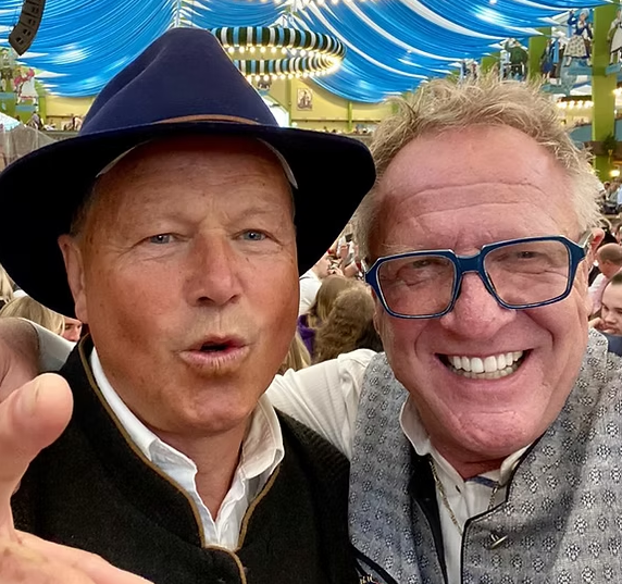 Two men wearing hats and glasses are posing for a picture together.