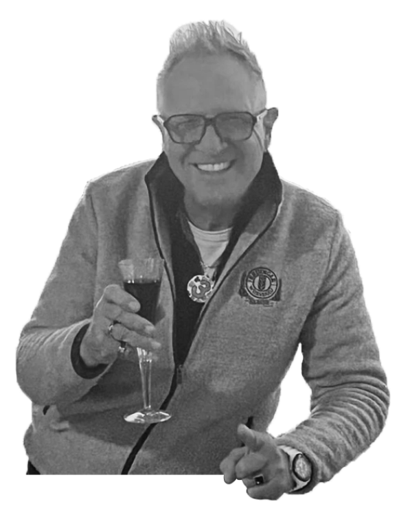 A man wearing glasses and a jacket is holding a glass of wine.