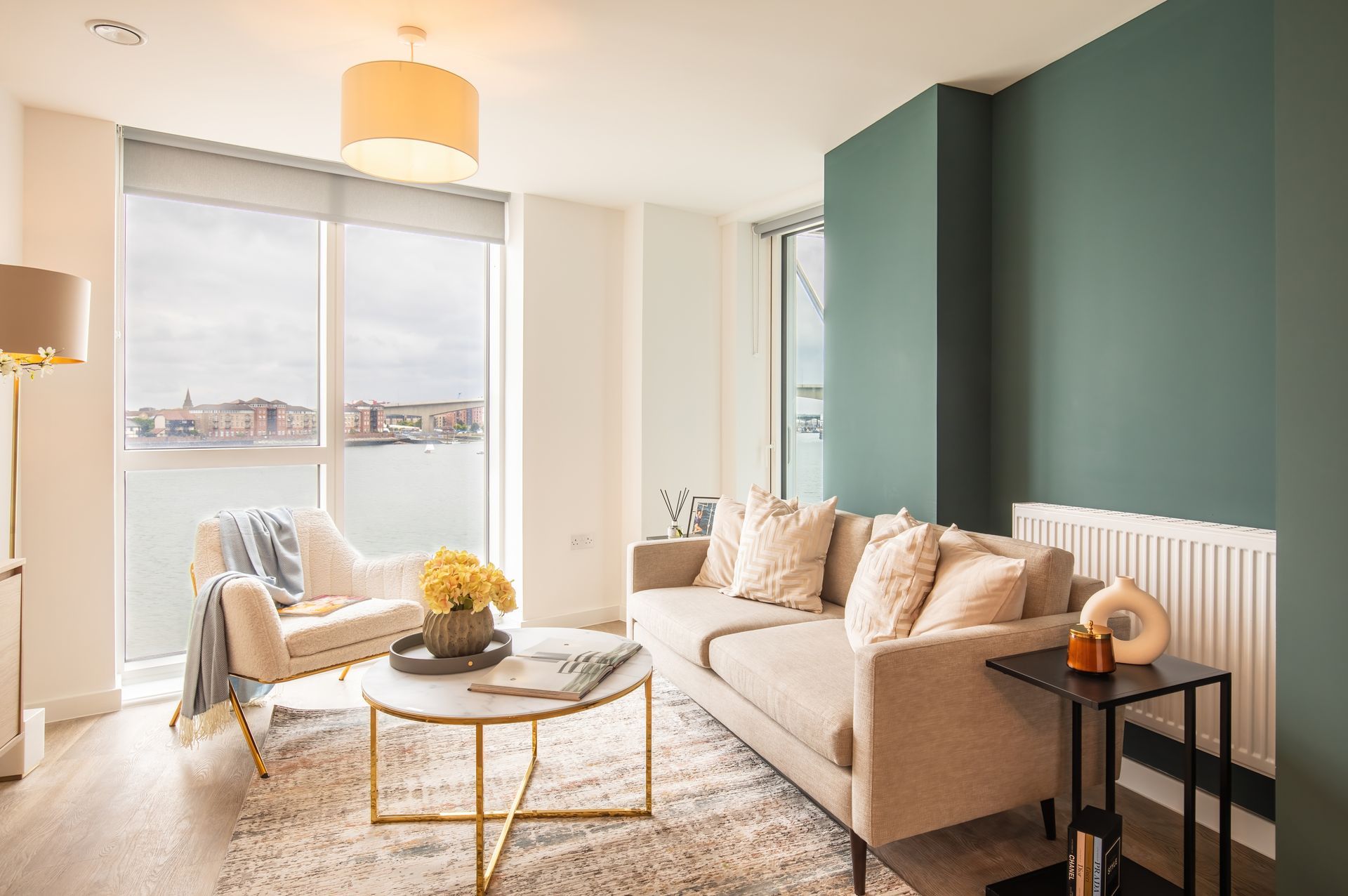 A living room with a couch , chair , coffee table and large windows.