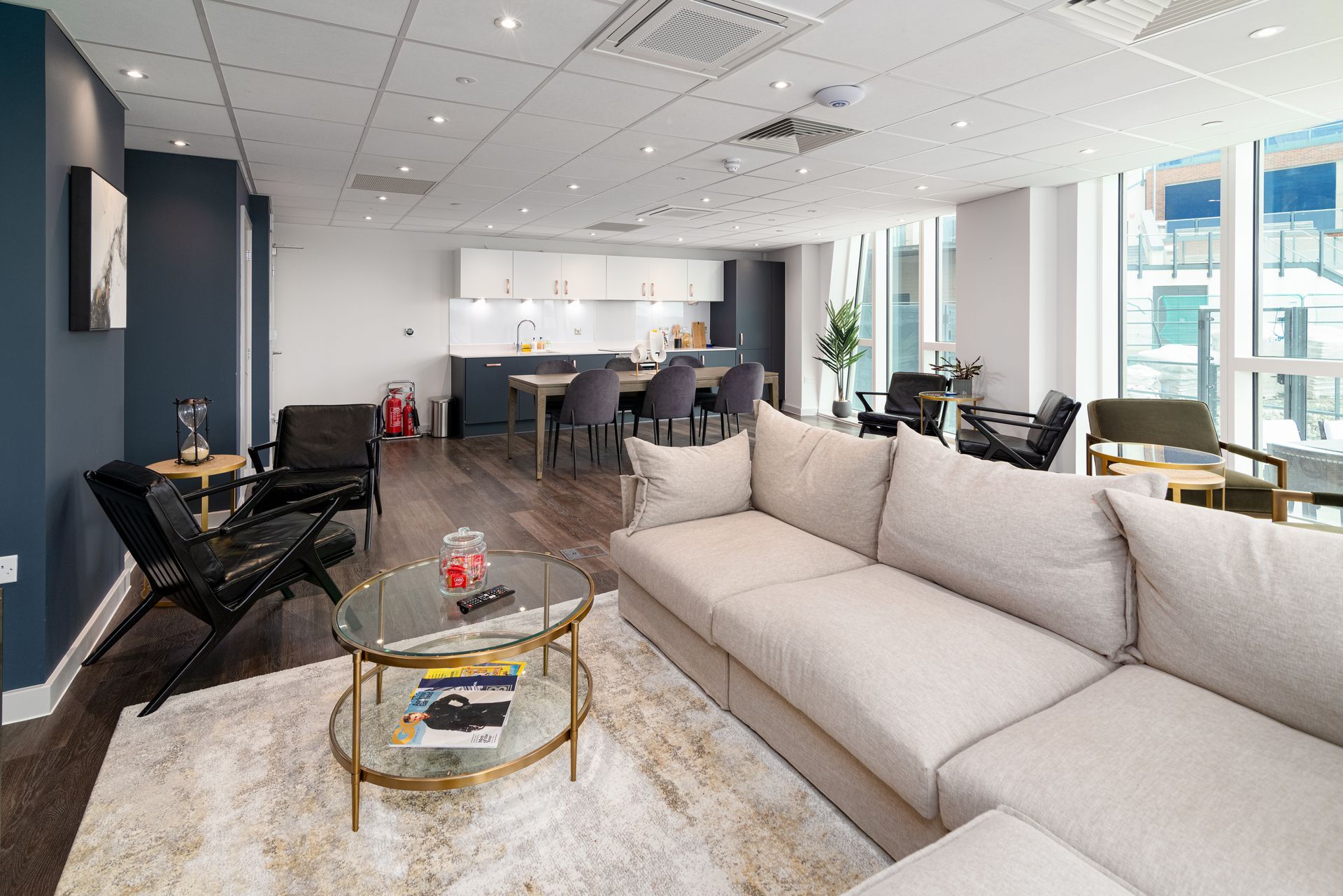 A living room with a couch , table , chairs and a rug.