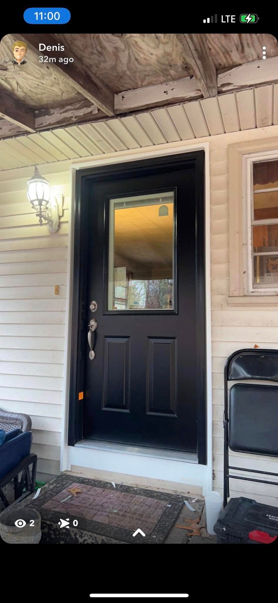 Front porch with a black door, white siding, and a ceiling light under the covered entry.
