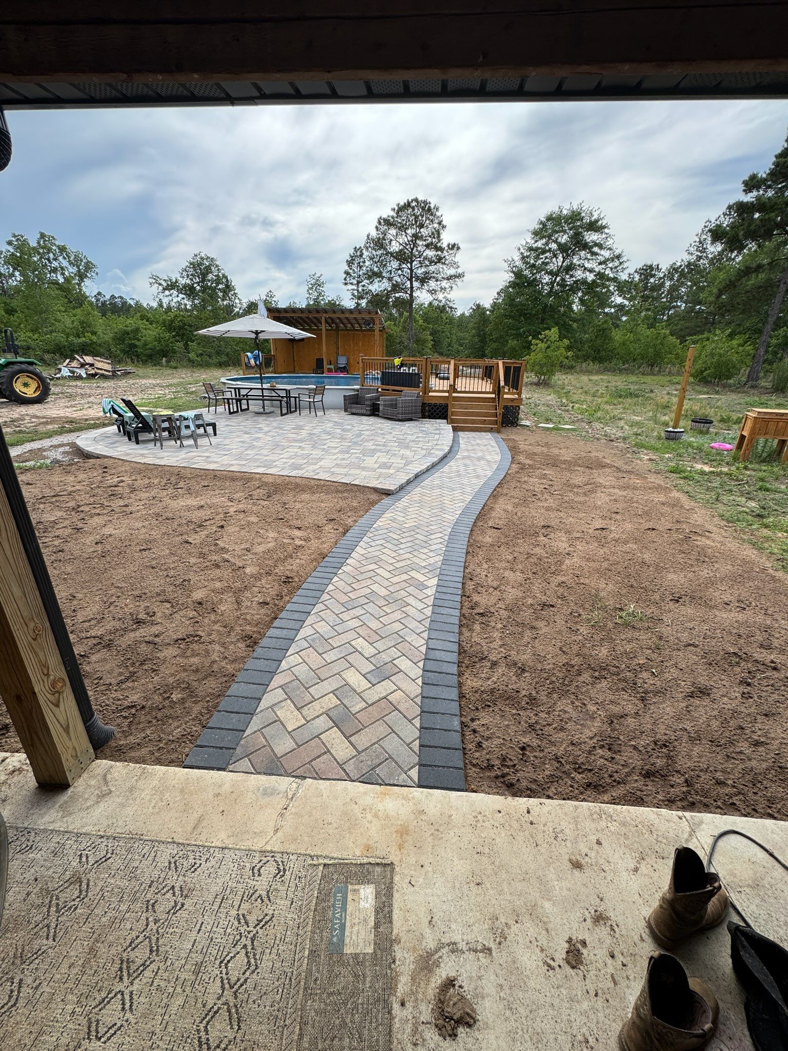 Circular stone fire pit with curved benches on a gravel patio in a wooded park area