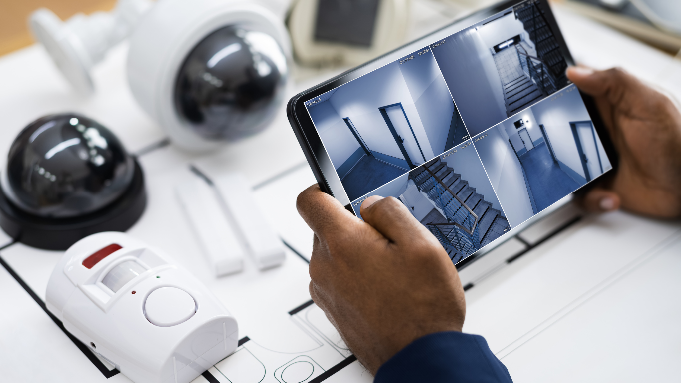 A person is holding a tablet with a security camera on it. - burglar alarm installation