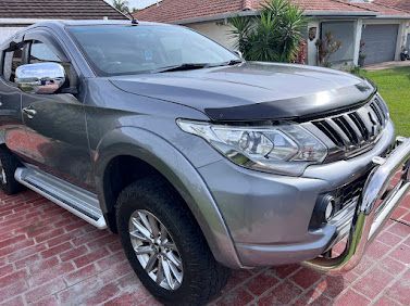 Silver SUV Parked In A Driveway Beside A House, Front View With Chrome Bull Bar And Side Steps — Car Detailing Mobile Cleaning Co In Port Macquarie, NSW