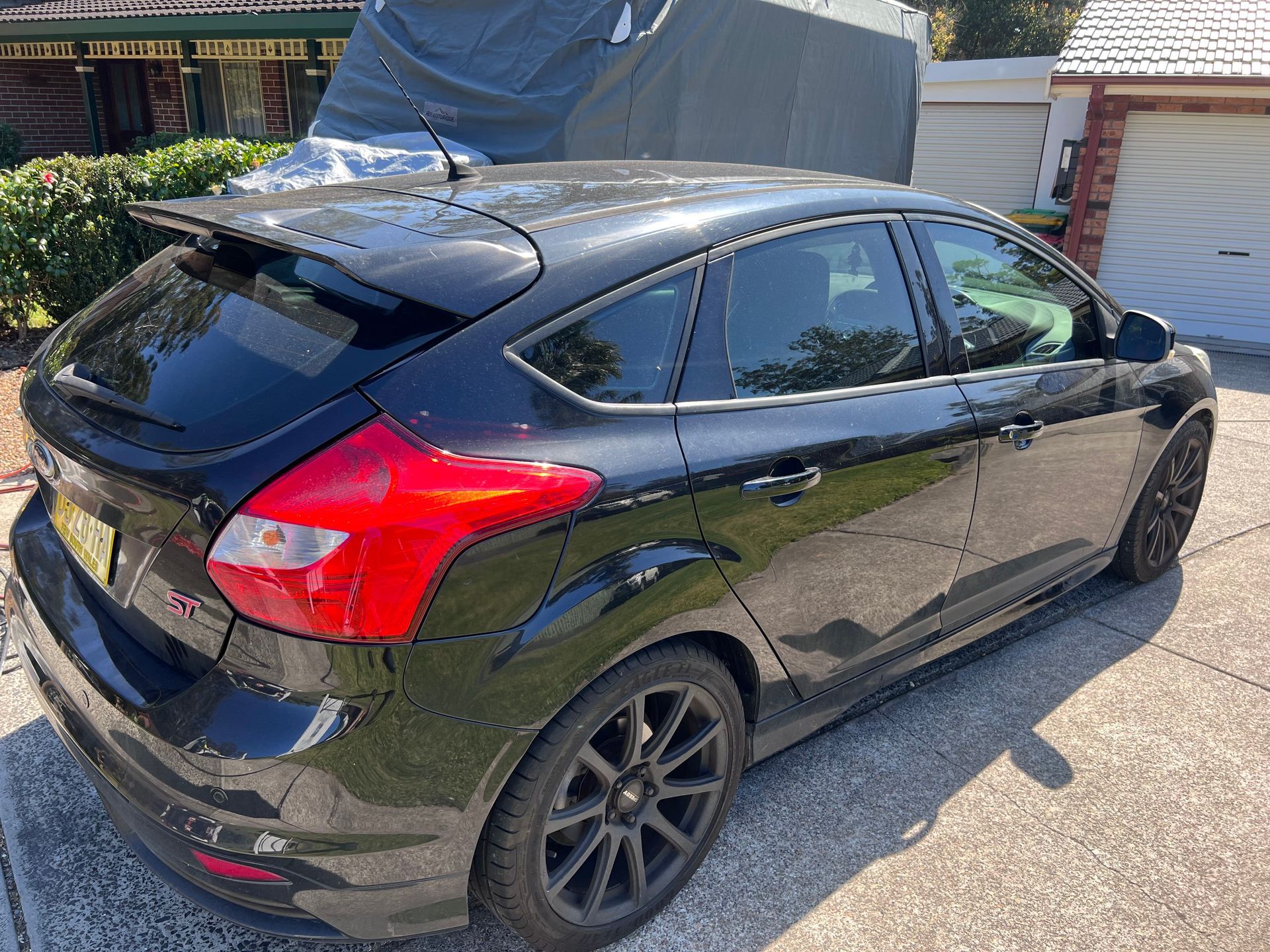 Black Hatchback Car Parked in a Driveway With a Covered Boat — Car Detailing Mobile Cleaning Co In Port Macquarie, NSW