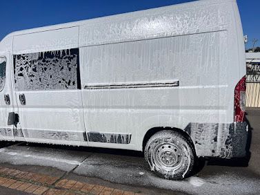 White Cargo Van With Muddy Lower Panels Parked On A Sunlit Street — Car Detailing Mobile Cleaning Co In Port Macquarie, NSW