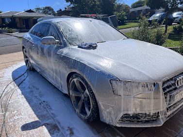 White Audi Sedan Covered In Foam During An Outdoor Car Wash On A Sunny Driveway — Car Detailing Mobile Cleaning Co In Port Macquarie, NSW