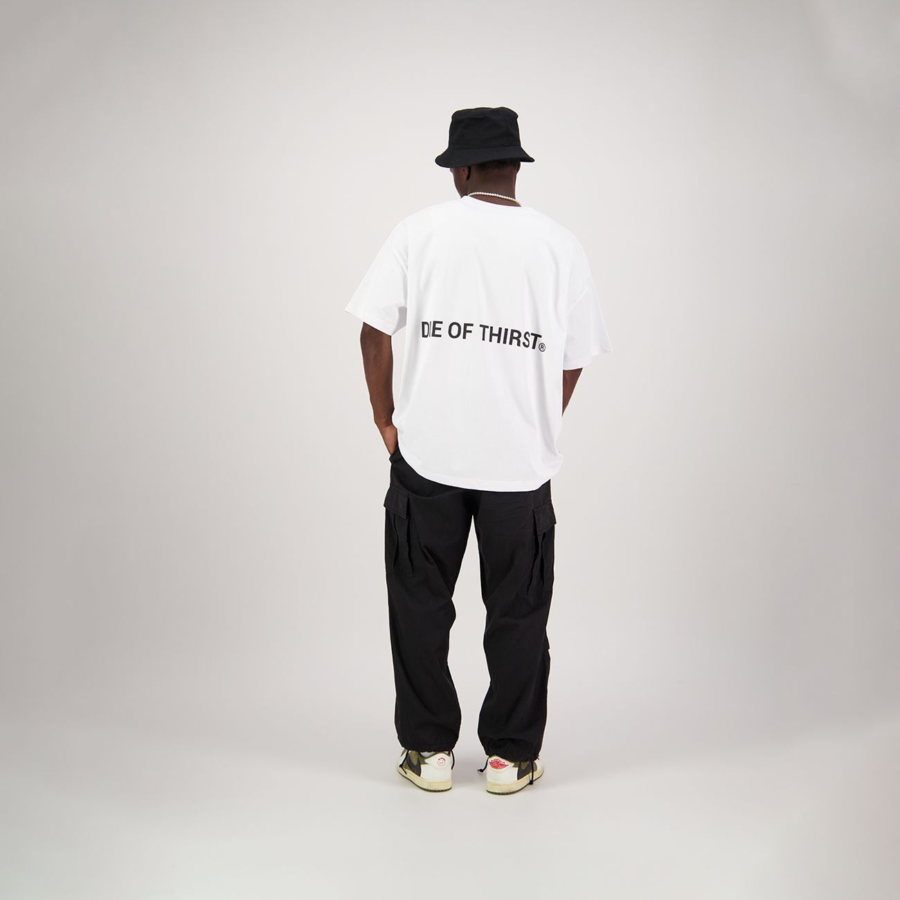 White oversized t-shirt with short sleeves; small logo on the chest and tag on the bottom left.