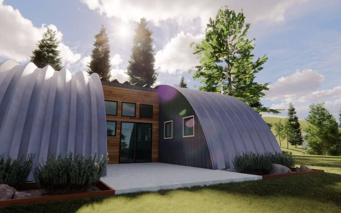 Modern house with curved silver walls and large windows, surrounded by trees under a cloudy sky