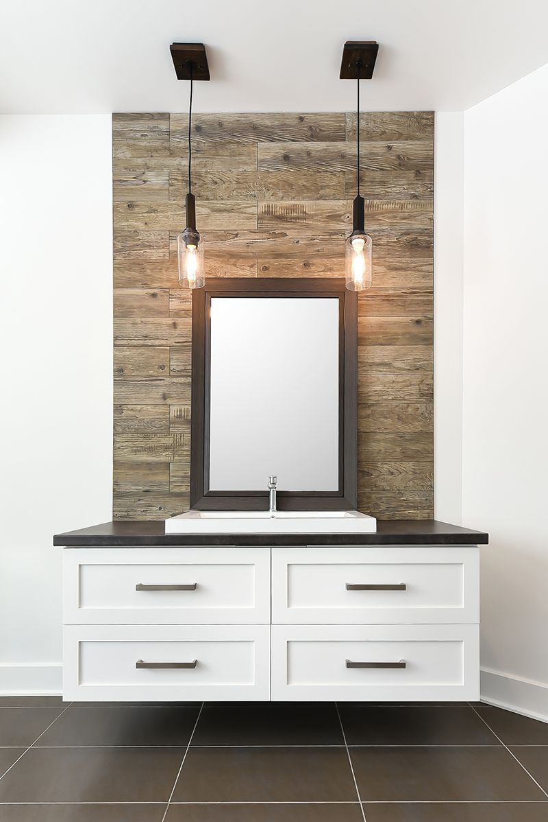 a bathroom with a sink , mirror and brick wall.