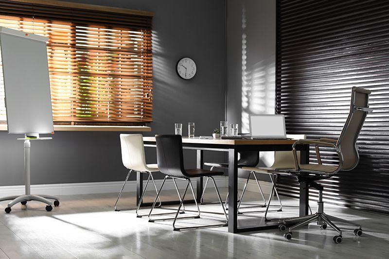 a conference room with a table and chairs and a clock on the wall .