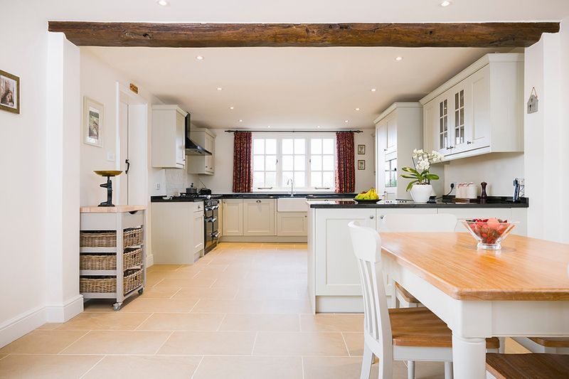 a kitchen with white cabinets and a wooden table