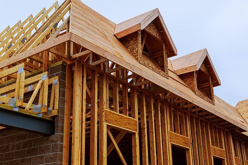 a house is being built with wooden beams and a roof .