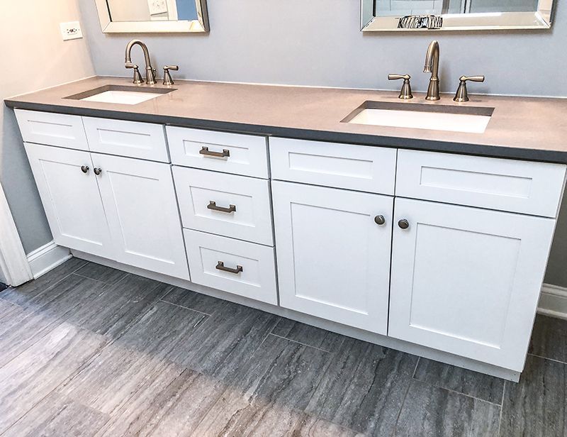 a bathroom vanity with two sinks and two mirrors .
