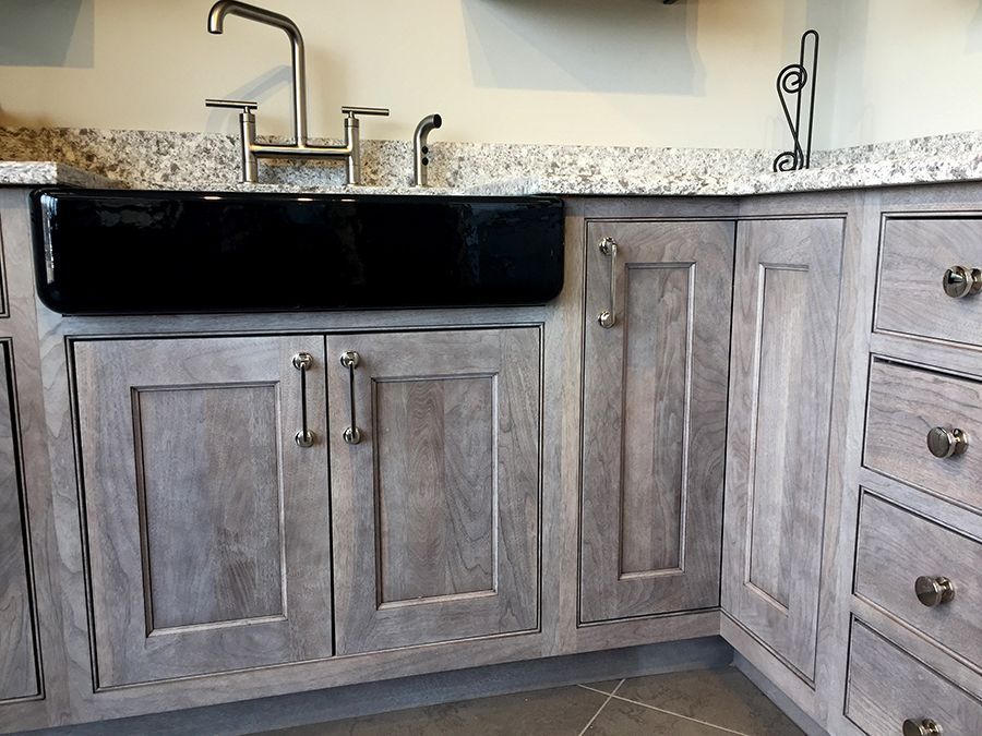 a kitchen with gray cabinets and a black sink