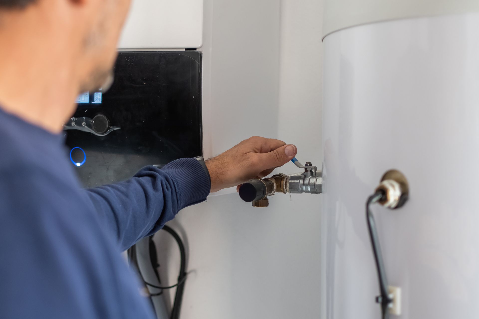 Technician adjusting a valve during water heater repair