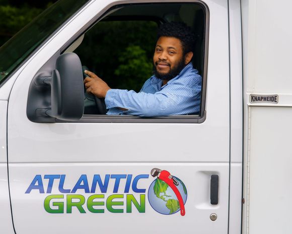 A person driving a white work van with an 