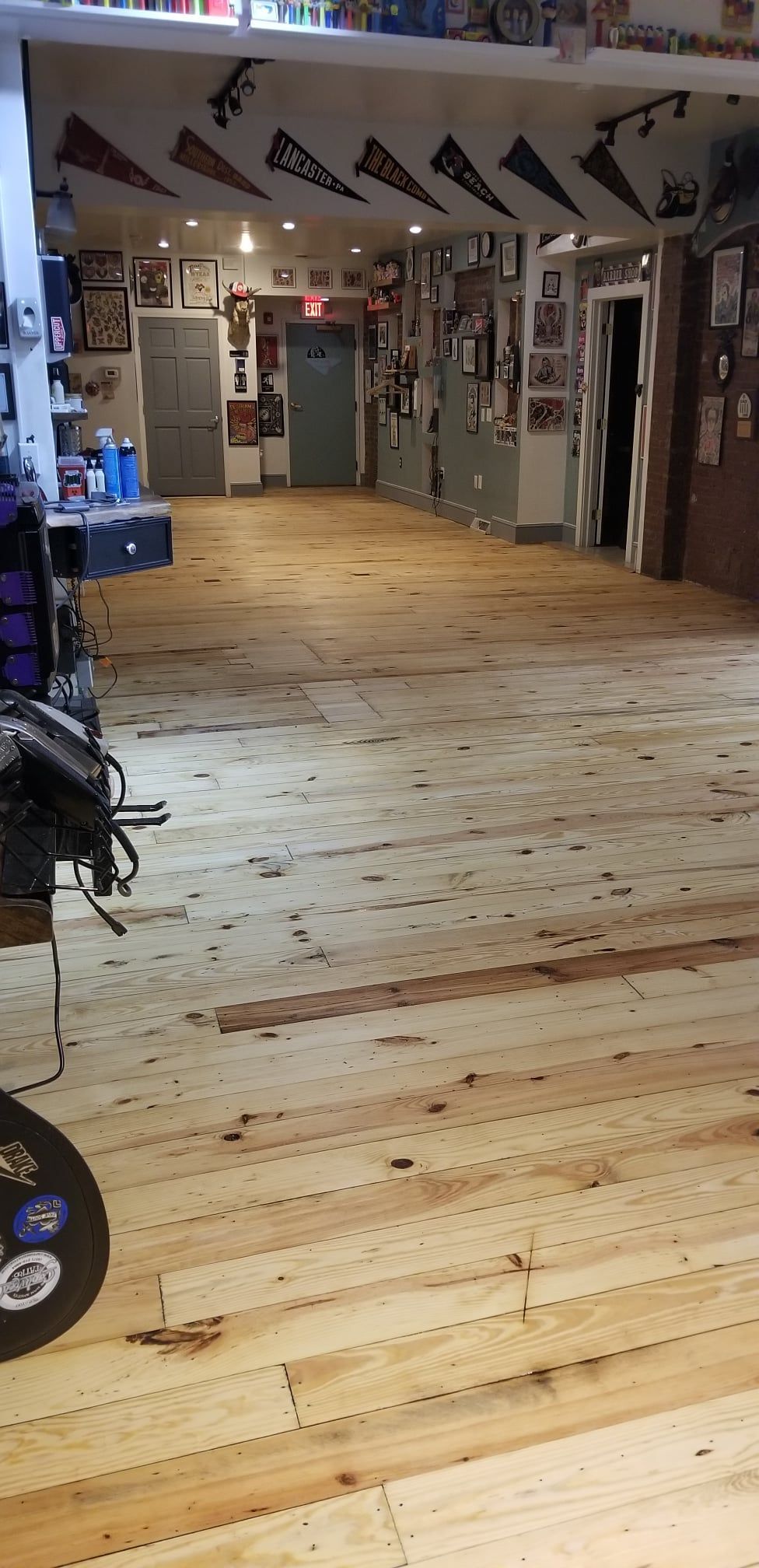 A wooden floor in a room with varsity flags on the ceiling