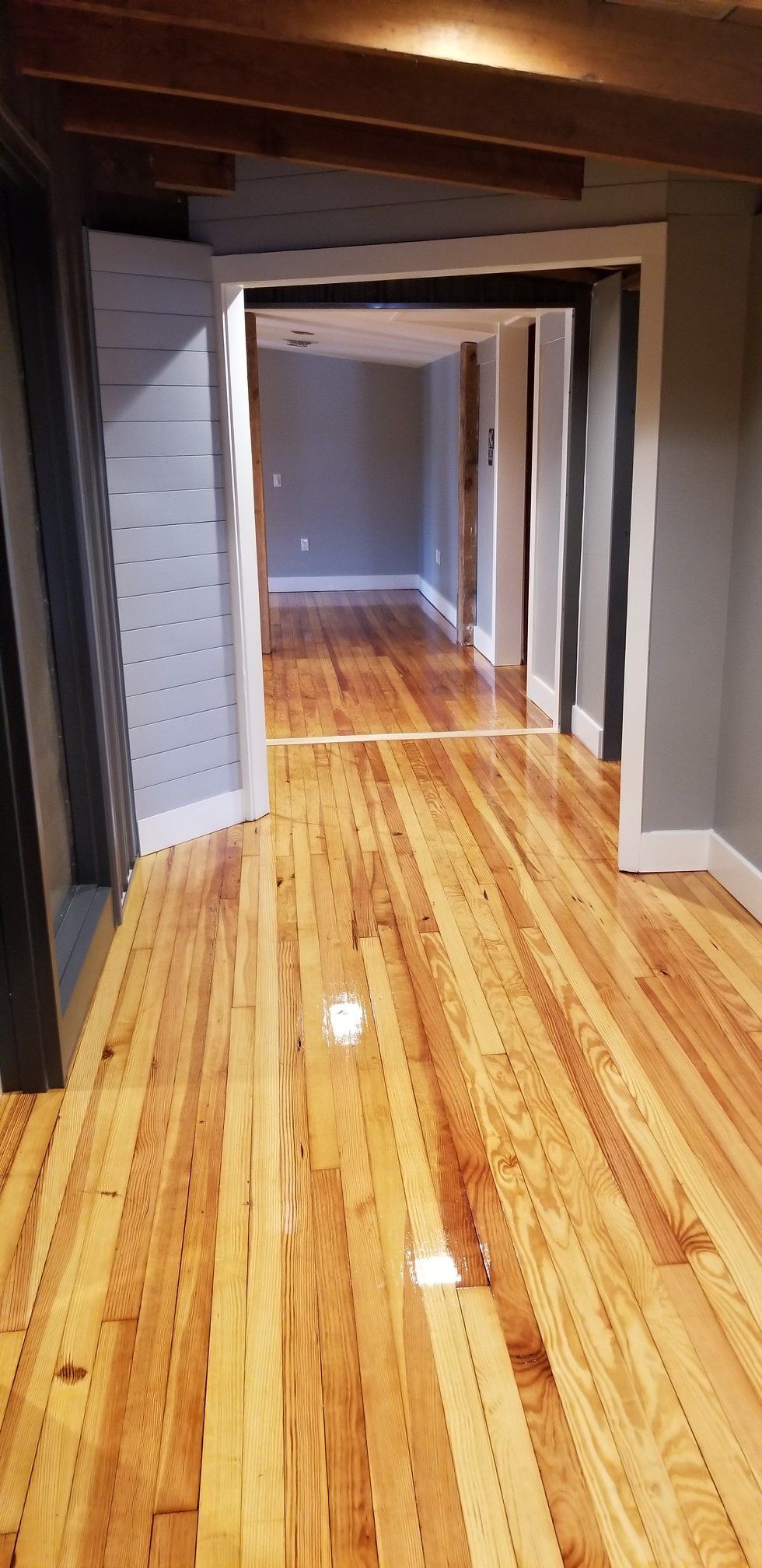 A hallway with a wooden floor and a doorway
