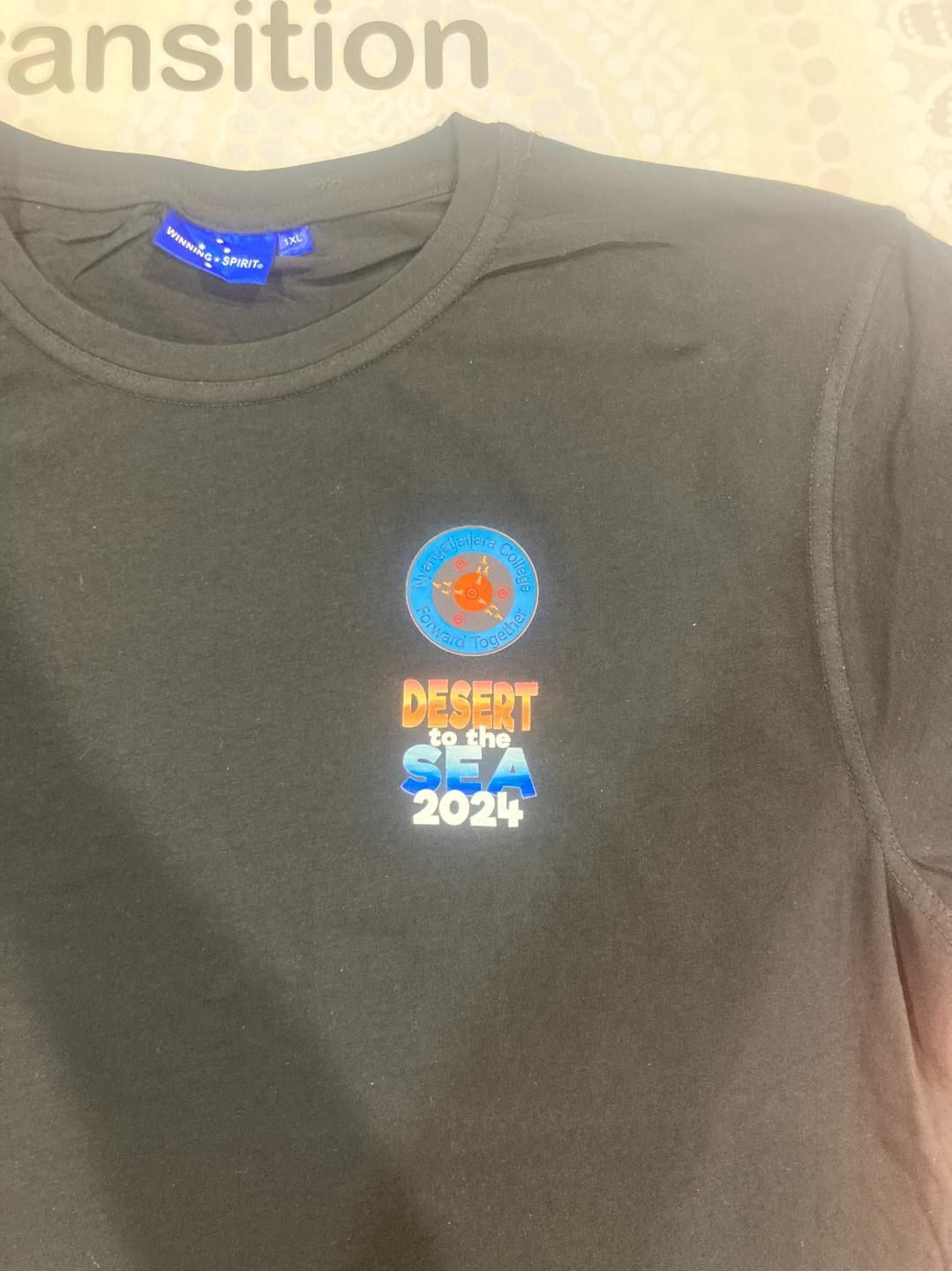 a Black T-shirt With a Blue Label That Says Transition — Pinpoint In Alice Springs, NT

