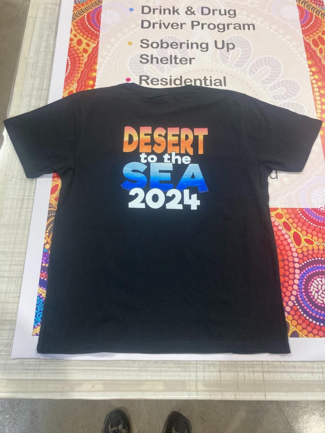 a Black T-shirt With the Words Desert to the Sea 2024 on It — Pinpoint In Alice Springs, NT
