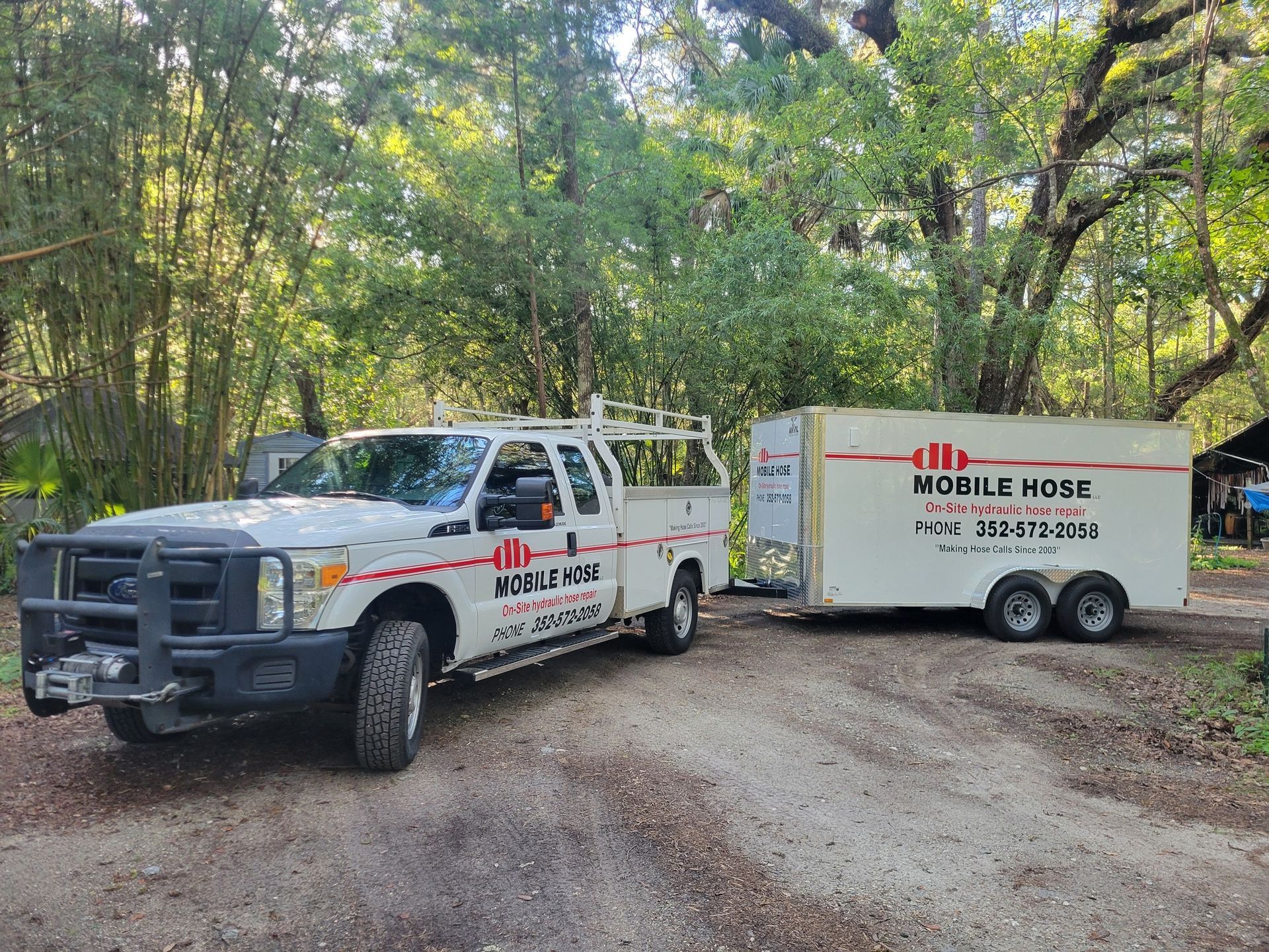 White truck with trailer, both labeled 