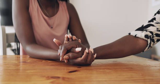 People holding hands and supporting each other through grief