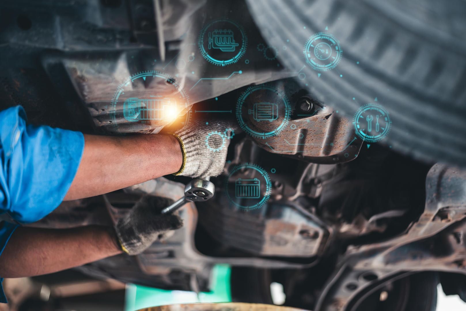 A man is working under a car with a wrench.