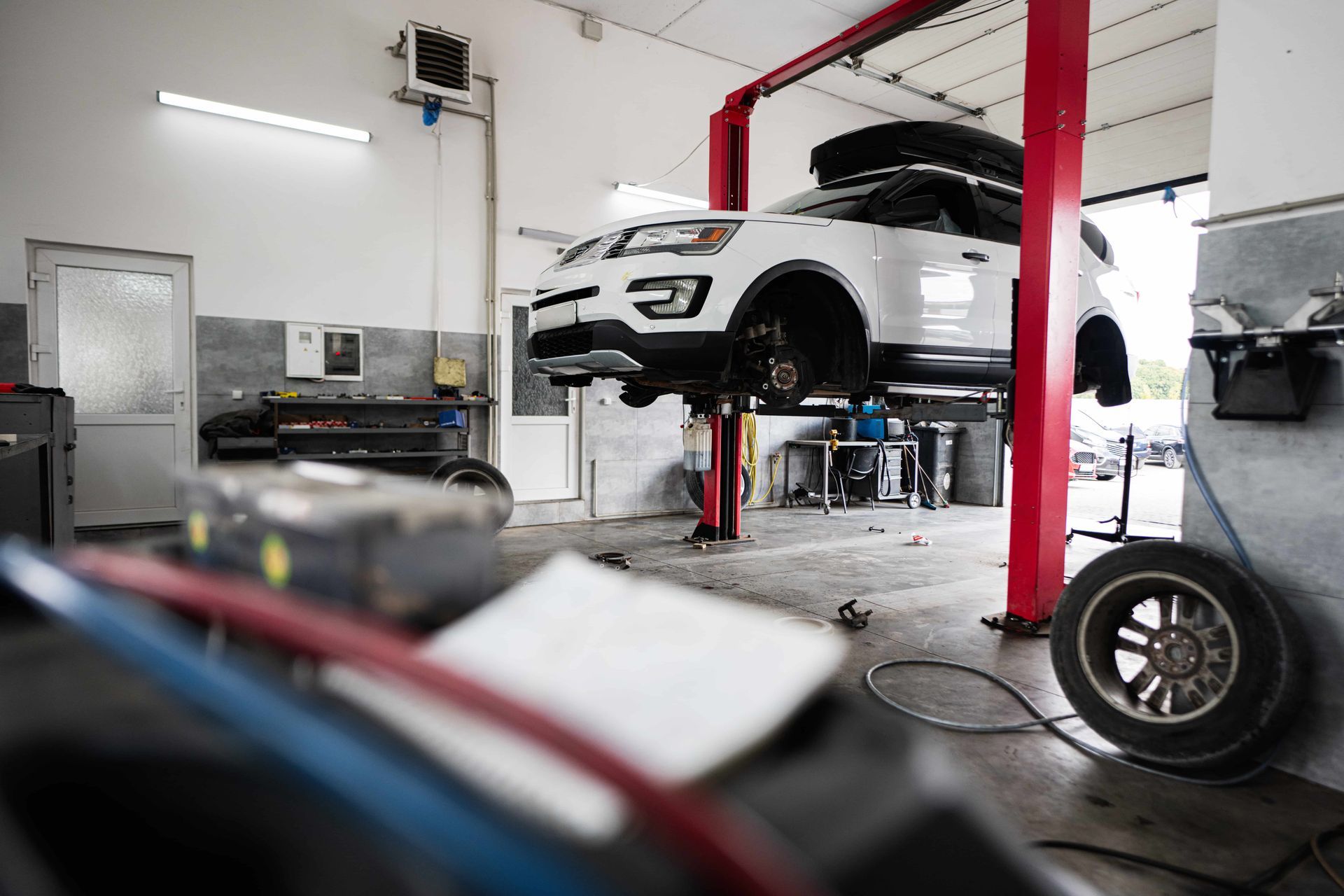 A car is sitting on a lift in a garage.
