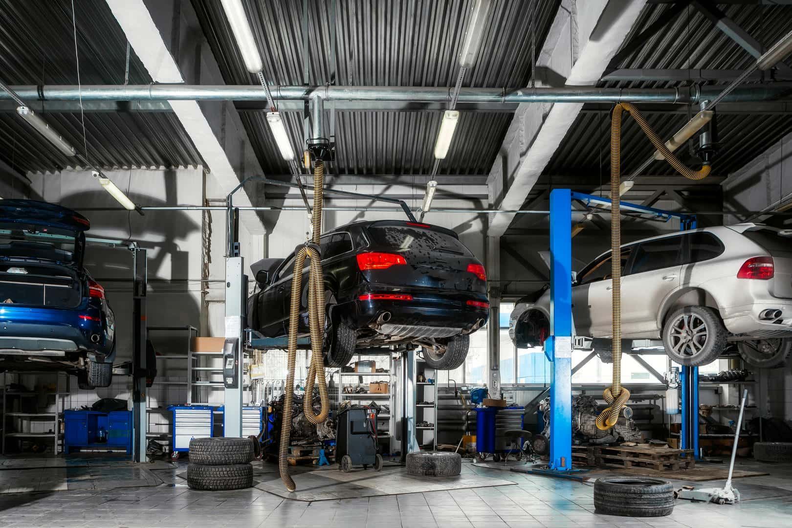 A car is sitting on a lift in a garage.