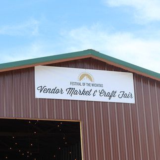 A barn with a sign on it that says vendor market & craft fair.